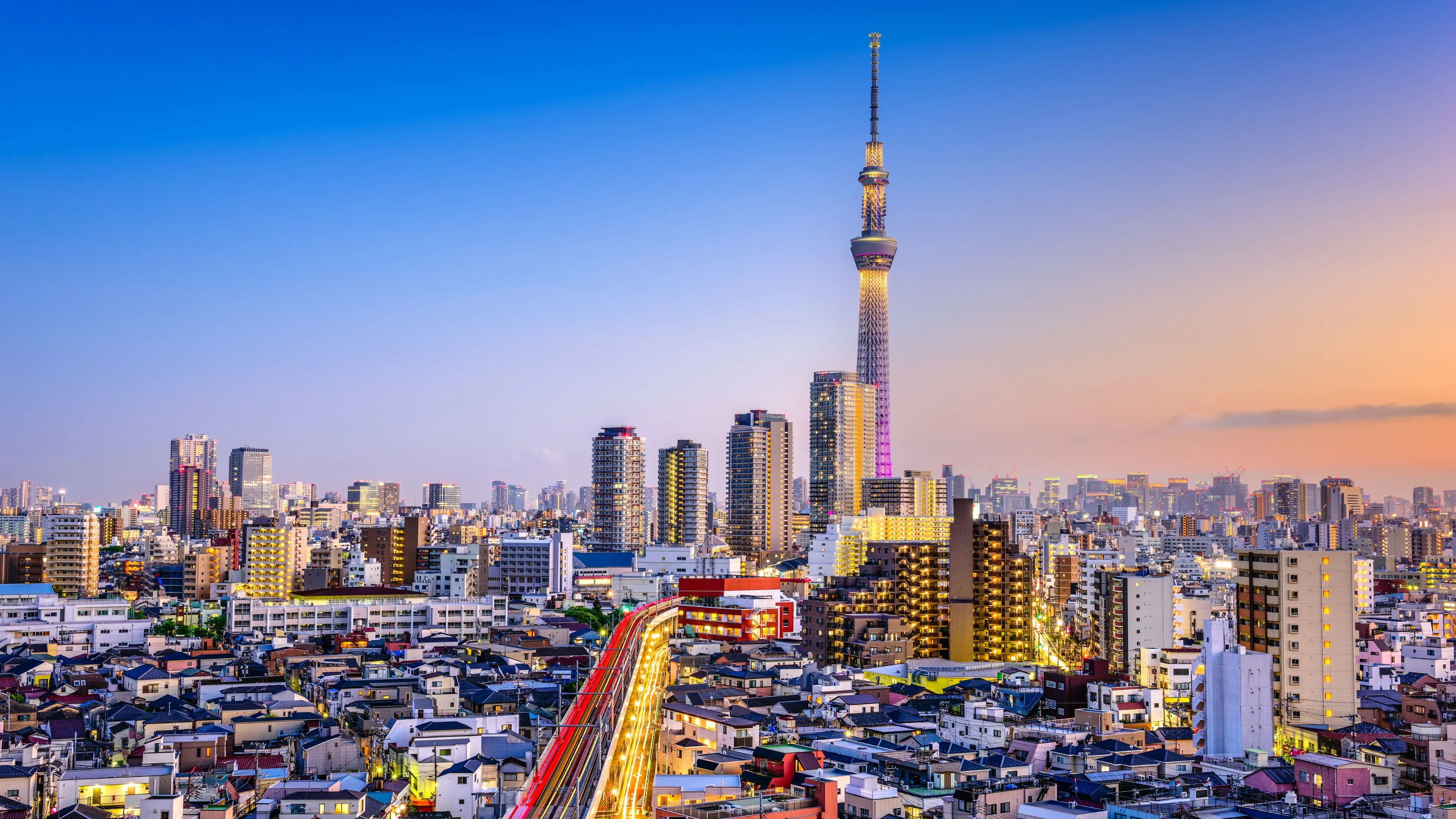 A city skyline at dusk with a tall tower, representing global markets